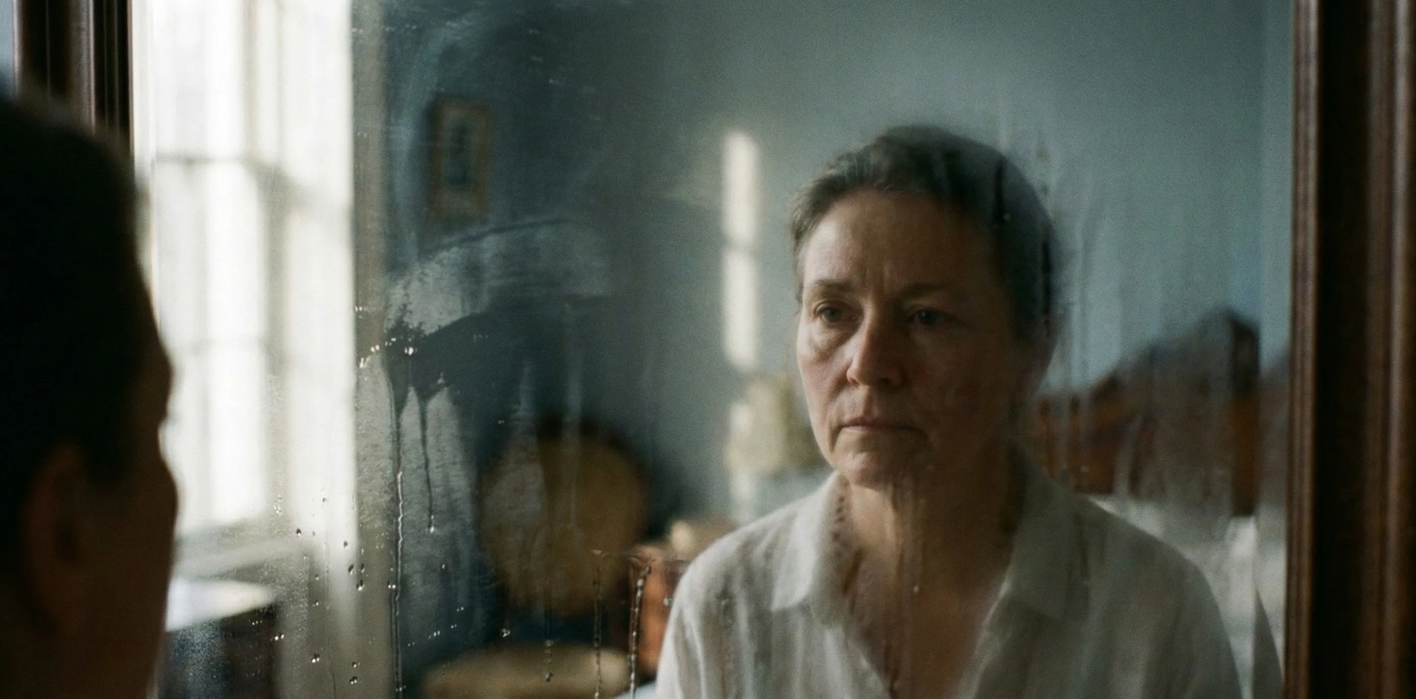 Mulher olhando seu reflexo no espelho, com semblante preocupado